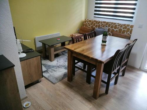 a dining room with a table and chairs with a bottle on it at Karbula Apartments & Villa in Mavrovo