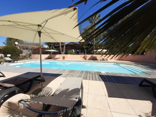 a pool with chairs and an umbrella next to a swimming pool at Villa Pinarello climatisée avec piscine chauffée in Sainte-Lucie de Porto-Vecchio