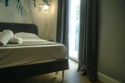 a bed with white pillows and a window in a room at Krysos Luxury Rooms in Agrigento