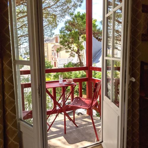 a red chair and a table on a balcony at Hôtel Le Saint Christophe in La Baule