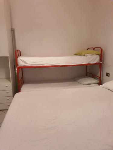 里米尼的住宿－Appartamento Viserba，配有两张双层床的小型客房,拥有白色的墙壁
