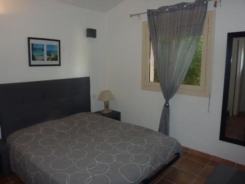 a bedroom with a bed and a window at Villa Pinarello climatisée avec piscine chauffée in Sainte-Lucie de Porto-Vecchio