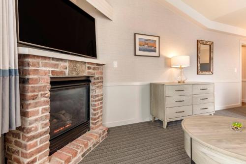 a living room with a fireplace with a flat screen tv at Mill Falls Resort Collection at the Lake in Meredith