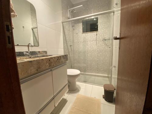 y baño con aseo, lavabo y ducha. en Casa Kiwi - Aluguel Temporada, en Porto Seguro