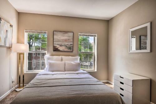 a bedroom with a large bed with two windows at Midtown Baltimore Hub Half Mi to Penn Station in Baltimore