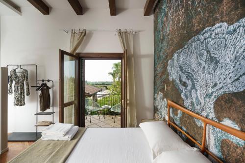 a bedroom with a large wall mural next to a bed at Cocciu D'Amuri in Mongiove