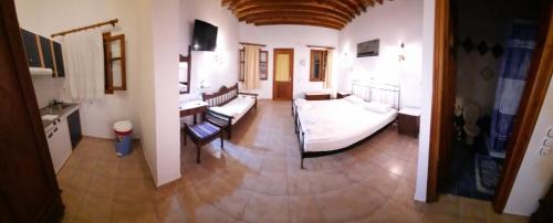 sala de estar con cama y sillas en una habitación en Thalatta, en Faros