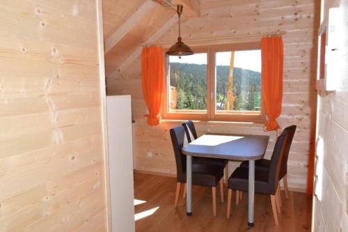 ein Esszimmer mit einem Tisch, Stühlen und einem Fenster in der Unterkunft Talhuette App.1 Lachtal 542 in Murau