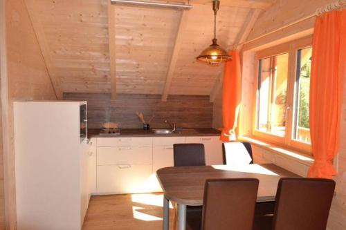 eine Küche mit einem Tisch und Stühlen sowie einem Kühlschrank in der Unterkunft Talhuette App.1 Lachtal 542 in Murau