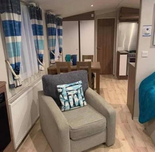 a living room with a chair and a kitchen at 8 Berth,Waterside Leisure,Ingoldmells in Ingoldmells