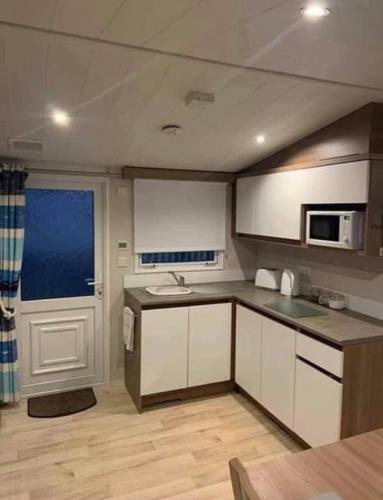 a kitchen with a sink and a microwave at 8 Berth,Waterside Leisure,Ingoldmells in Ingoldmells