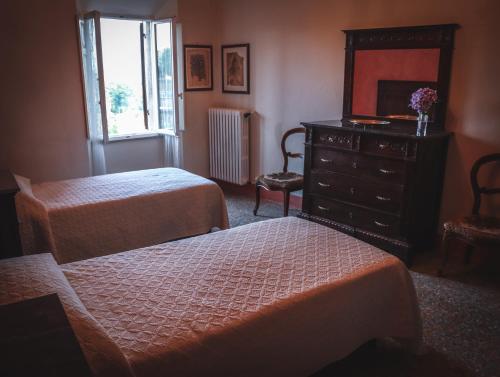 a bedroom with two beds and a dresser and a mirror at Casa Anna "a lovely home in Tuscany" in Colle Val D'Elsa