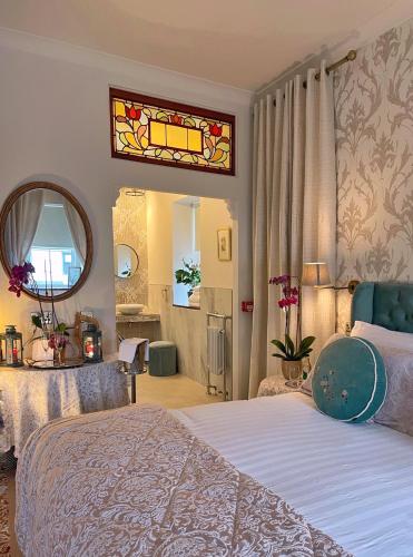 a bedroom with a bed and a mirror at Bedford House & Hall in Balbriggan