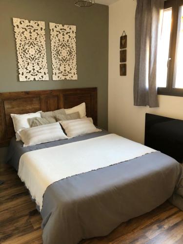 a bedroom with a large bed with white sheets at chalet avec vue lac in Embrun