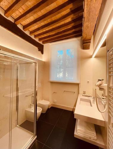 a bathroom with a shower and a sink and a toilet at Palazzo Borgocolonne Apartments in Parma