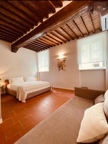 パルマにあるPalazzo Borgocolonne Apartmentsのベッドルーム1室(ベッド1台、ソファ付)