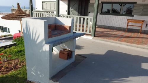a white stove sitting on the side of a porch at 2 bungalows avec vue sur mer et piscine PARTAGEE in Oualidia