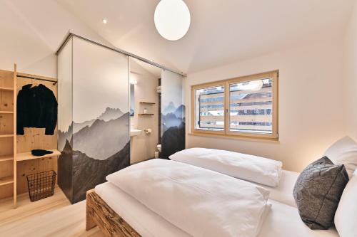 1 dormitorio con 2 camas y ventana en Wald 12 Ferienhaus, en Wald am Arlberg
