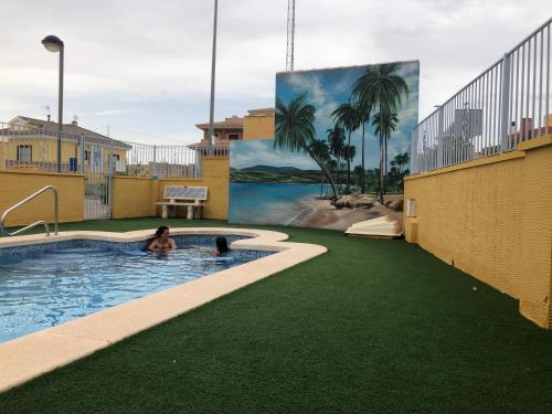 uma mulher na piscina de um resort com um mural em Beautiful Villa in Murcia with pool just 10m away em Múrcia