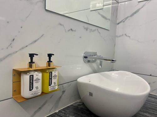 a white bathroom with a sink and a toilet at Hotel Vrindavan Palace in Indore