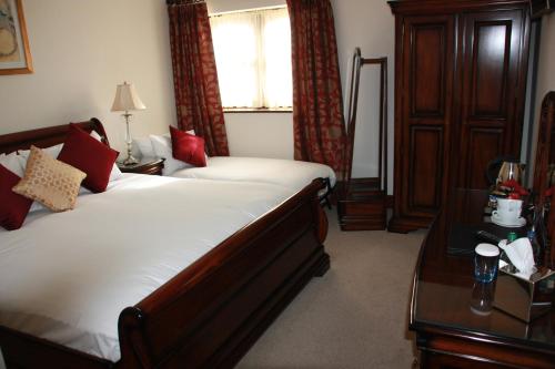 a bedroom with a bed and a table and a window at Chester Beatty Inn in Ashford