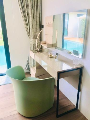 a desk and a green chair in a room at Villa MAI MEE PAN HA 3 bedrooms in Nai Yang Beach