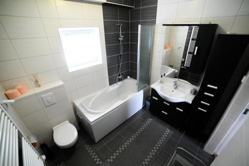 a bathroom with a tub and a toilet and a sink at Apartman EMA in Velika Gorica