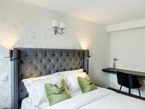 a bedroom with a large bed with green pillows at MOYÏ in Basse-Goulaine