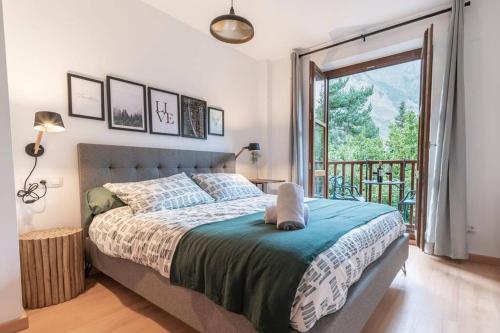 a bedroom with a bed and a balcony at Casa Sanchines - Apartamentos Loira in Benasque