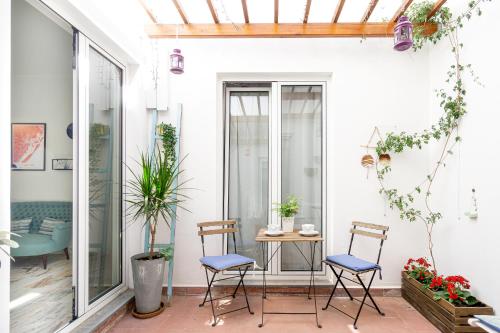 a patio with two chairs and a table at Casas da Formosa - Downtown Alegria in Tavira