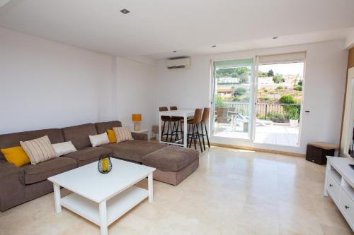sala de estar con sofá y mesa en Casa Pitufo Calpe, bright duplex - see & mountain view, en Calpe