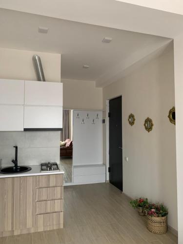 a kitchen with white cabinets and a counter top at Valkhida's Apartment in Kutaisi