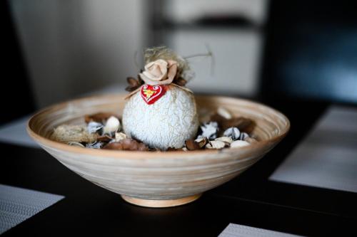 a small figurine sitting in a bowl on a table at Apartman EMA in Velika Gorica