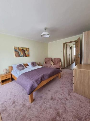 - une chambre avec un grand lit et des couvertures violettes dans l'établissement Del Mar Gdynia, à Gdynia