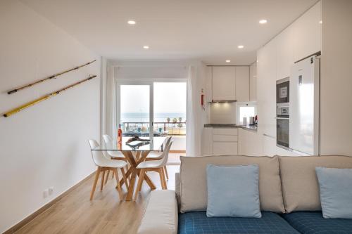 a living room with a couch and a table at Ocean View Balcony Carcavelos Beach 2-min Walk, AC in Carcavelos