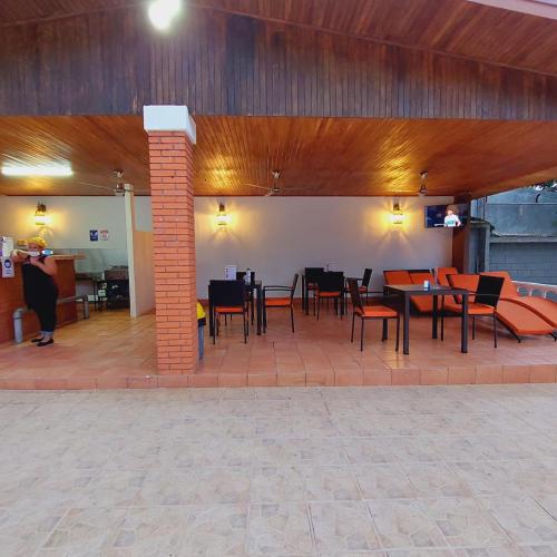 a patio with tables and chairs in a building at Uruka Lodge in Alajuela City