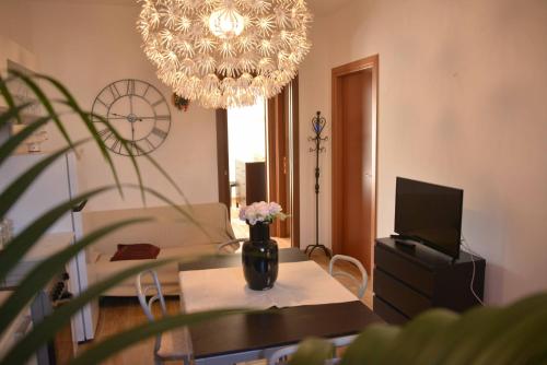 een woonkamer met een tafel en een kroonluchter bij Villetta de Mar in Civitanova Marche