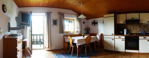 una cucina con tavolo e sedie in una stanza di Ferienwohnung Wechselberger a Kiefersfelden