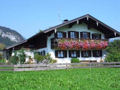 a house with a balcony with flowers on it at Ferienwohnung Wechselberger in Kiefersfelden