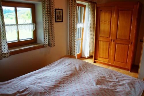 een slaapkamer met een bed, een raam en een deur bij Ferienwohnung Wechselberger in Kiefersfelden