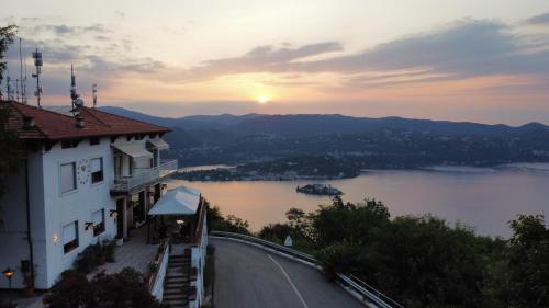 een gebouw op een heuvel met uitzicht op een meer bij Hotel Panoramico lago d'Orta in Madonna del Sasso