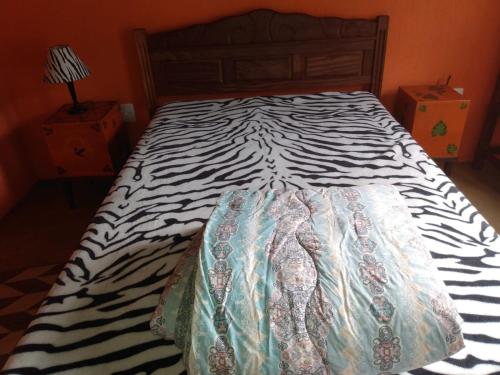 a zebra print bed in a bedroom at Pouso da Lua in São Pedro da Serra