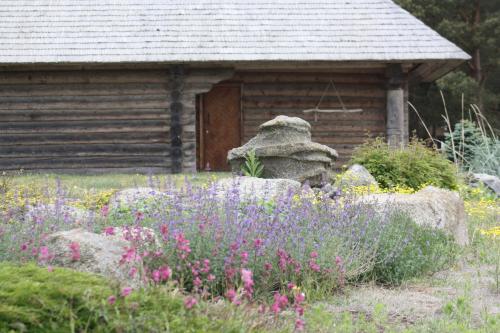 a cabin with a garden with flowers in front of it at Sunset House in Ulmale