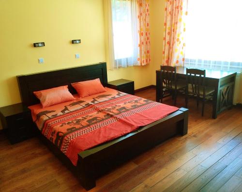 a bedroom with a bed and a table and a window at Стаи за Гости Lavender Lozen in Lozen