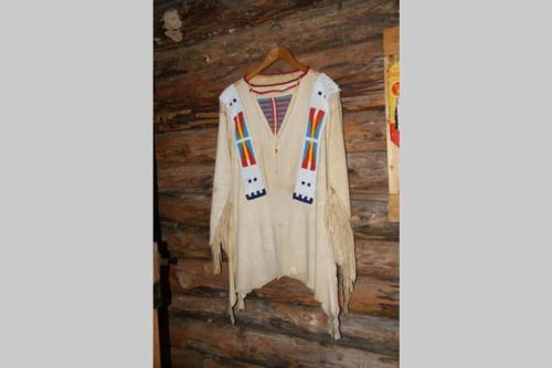 a white jacket hanging on a wooden wall at Chez Buddy - cabane de trappeur in Peaugres
