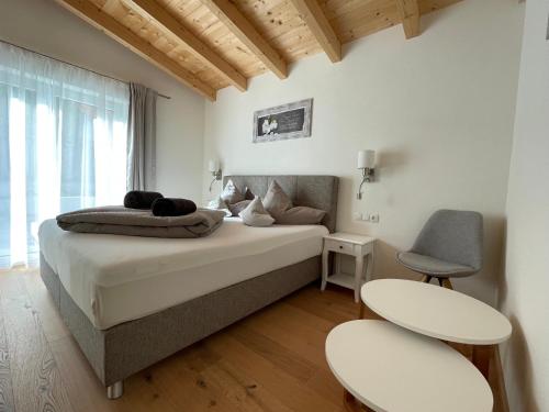 a bedroom with a bed with two tables and two chairs at Chalet Hackl in Sautens