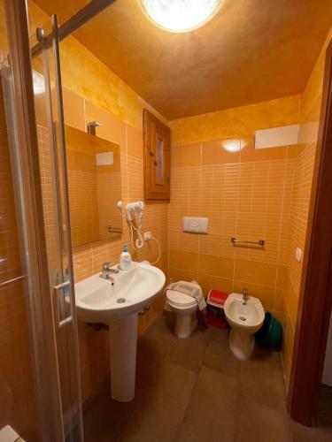 un bagno con lavandino e WC di Chalet monolocale a Vieste