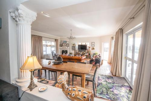 una sala de estar con una mesa y un sofá en The Paper Fig House, en Plettenberg Bay