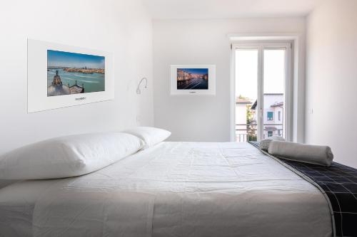 a white bedroom with a large white bed with a window at Verona Suites in Verona