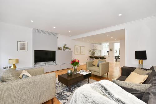 a living room with two couches and a flat screen tv at London Choice Apartments - Mayfair - Piccadilly in London